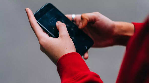 Holding phone with both hands, using both thumbs to type.
