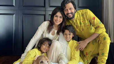 Riteish Deshmukh with his sons and Genelia D'Souza, smiling at the paparazzi.